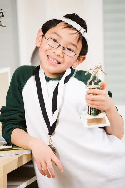 Rapaz vencedor com a sua medalha e troféu — Fotografia de Stock
