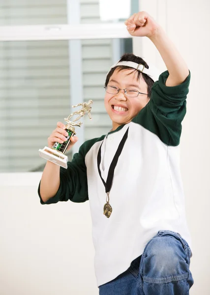 Мальчик-победитель с медалью и трофеем — стоковое фото
