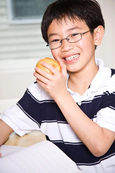 Ученик ест яблоко — стоковое фото