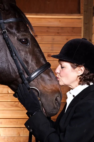 Senior mulher beijando seu cavalo — Fotografia de Stock