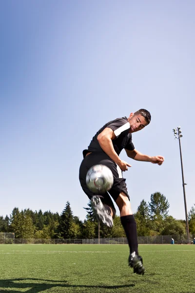 Jugador hispano de fútbol o fútbol pateando una pelota Imagen De Stock