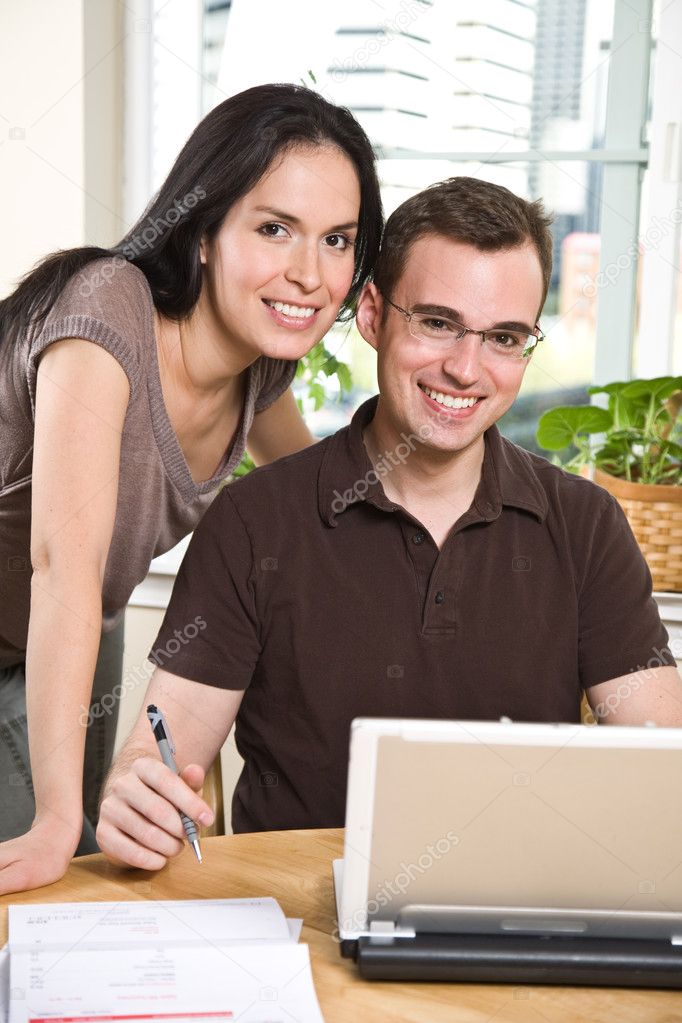 Couple paying bills by online banking