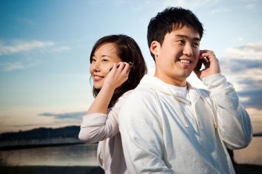 Asian couple on the phone clipart