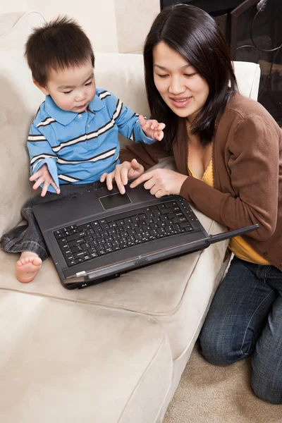 ノートパソコンを持つ母親と息子は — ストック写真