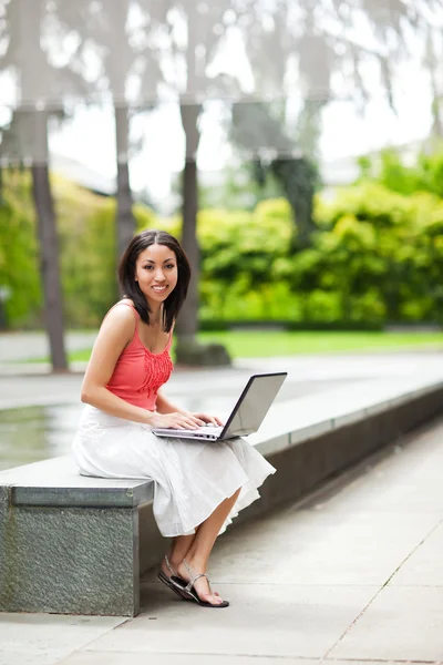 Kvinna på telefonen och arbetar på sin laptop — Stockfoto