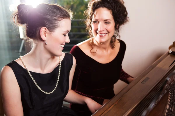 Mãe e filha tocando piano — Fotografia de Stock