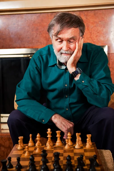 Starší muž hraje šachy — Stock fotografie