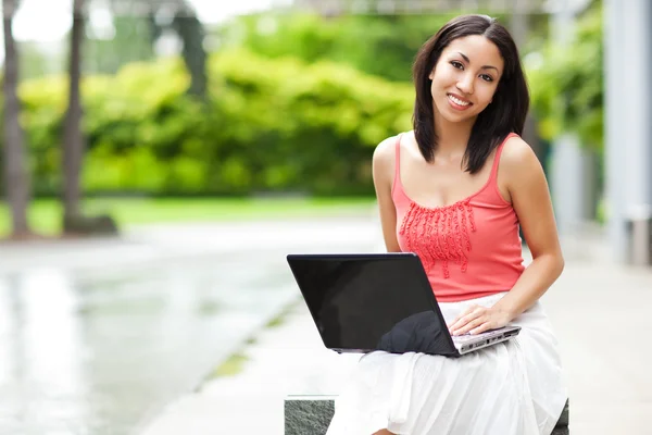 Kvinna på telefonen och arbetar på sin laptop — Stockfoto
