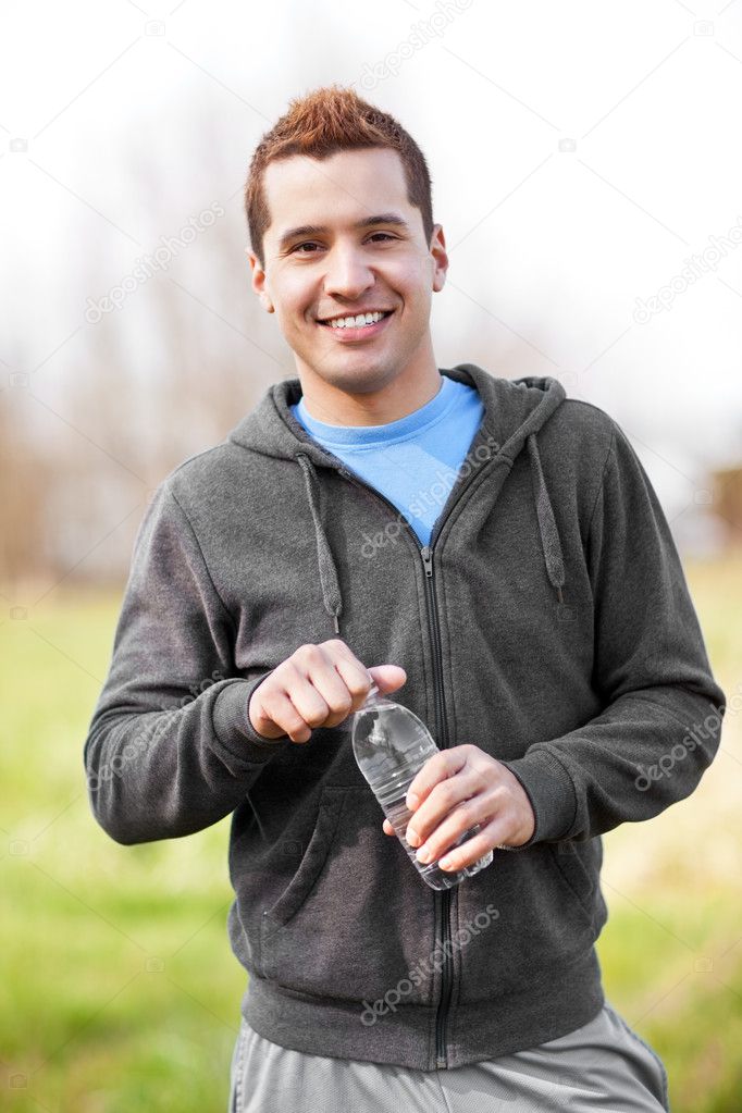 Mixed race man holding water bottle