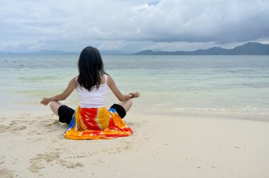 çekici bir genç kadın olarak yoga tarzı içinde ön plaj gerçekleştirir.