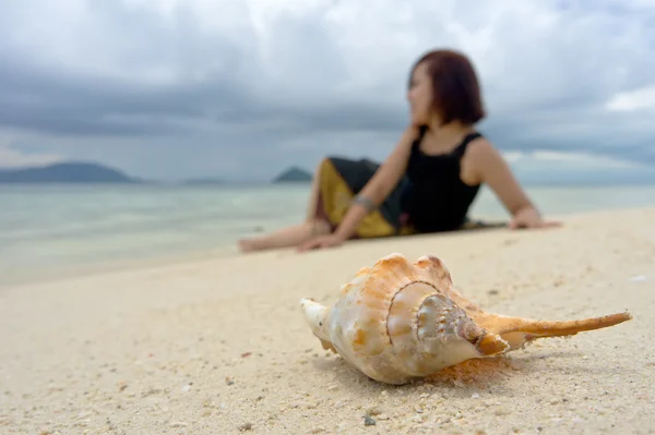 ontspannen jonge vrouw zit als achtergrond terwijl de krab shell in focus als voor
