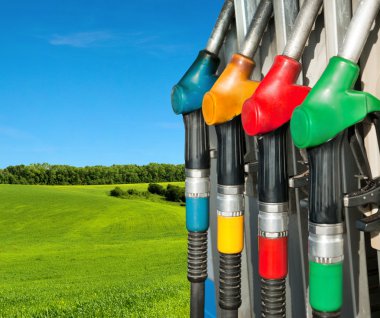 Gas pump nozzles over a nature background clipart