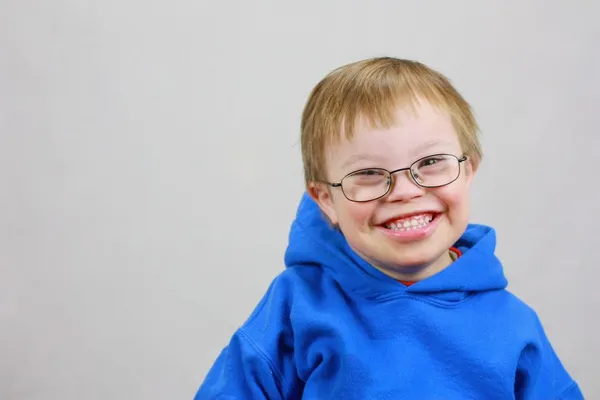 Мальчик с синдромом Даунса и очень счастливой улыбкой — стоковое фото