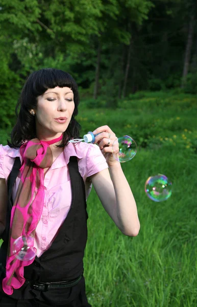 Kvinnan blåser såpbubblor — Stockfoto