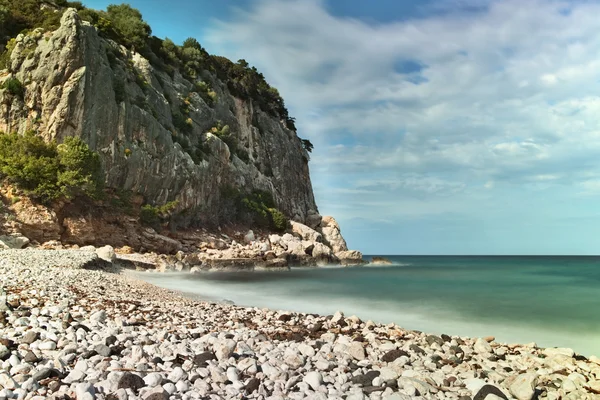 Yüksek kayalıklarla ve kayalık plaj beyaz çakıl — Stok fotoğraf