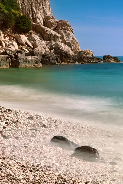 Plaża skalista skały wysokie niebieskie morze — Zdjęcie stockowe