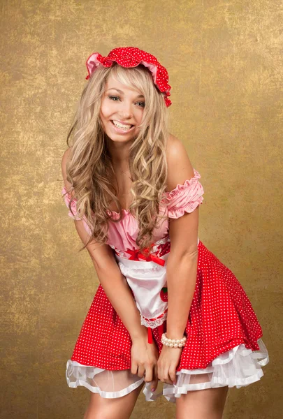Сексуальна блондинка в червоній вінтажній сукні на золотому фоні — стокове фото