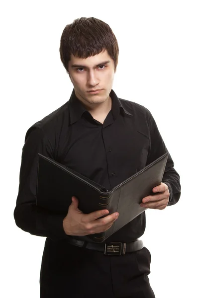 Vážný muž v černé košili s knihou izolovaných na bílém poza — Stock fotografie