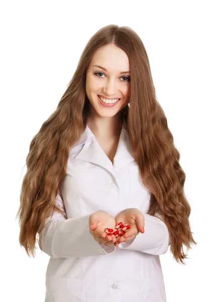 Giovane medico con pillole rossi nelle mani su sfondo bianco — Foto Stock
