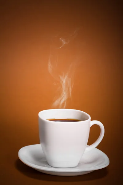 Белая чашка кофе на коричневом фоне — стоковое фото
