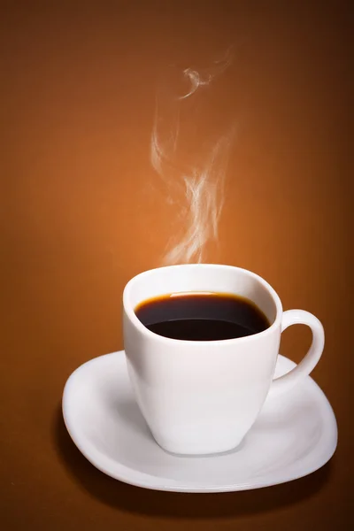 Weiße Kaffeetasse auf braunem Hintergrund — Stockfoto