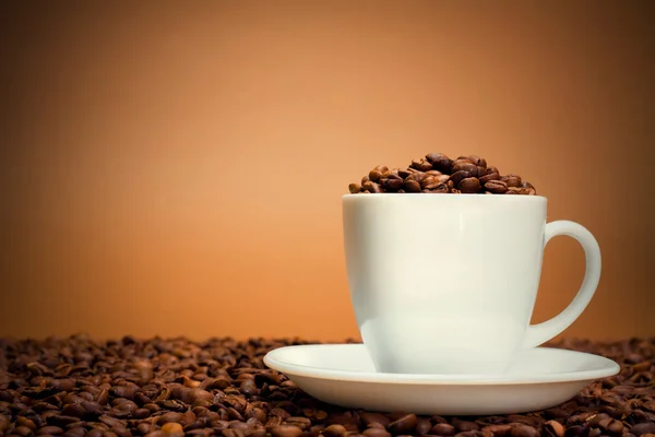 Белая чашка с кофейными зёрнами — стоковое фото