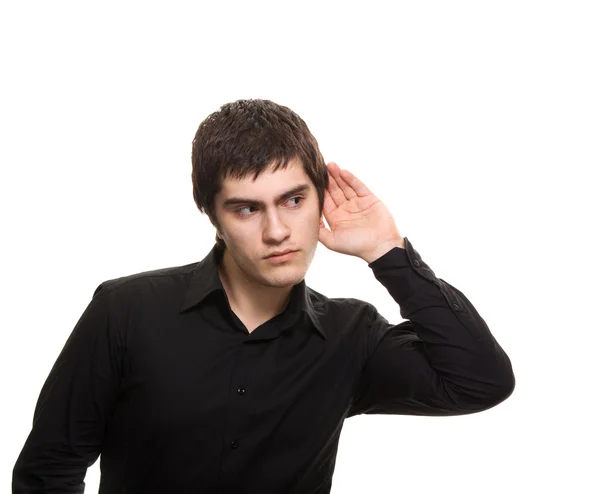 Genç izole beyaz zemin üzerine siyah tişörtlü adam kulak misafiri. — Stok fotoğraf