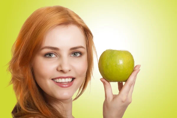 Молодая красотка с яблоком на зеленом фоне — стоковое фото