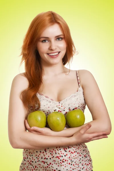 Piękna młoda kobieta z jabłkiem na zielonym tle — Zdjęcie stockowe