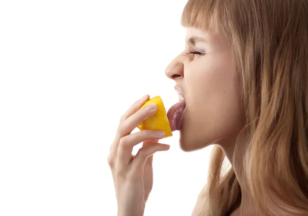 Молода дівчина тримає кислий лимон ізольовано — стокове фото