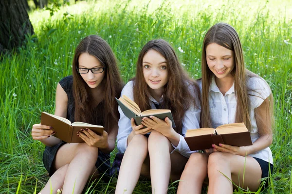 Три студента, чтение книг вместе открытый — стоковое фото
