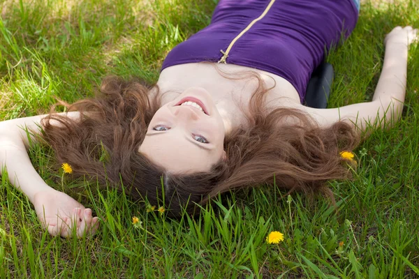 Young beautiful teenager on dandelion lawn — Stock Photo, Image