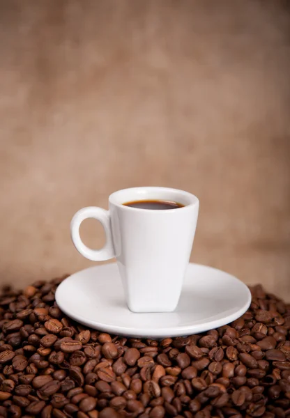 Taça branca e grãos de café — Fotografia de Stock