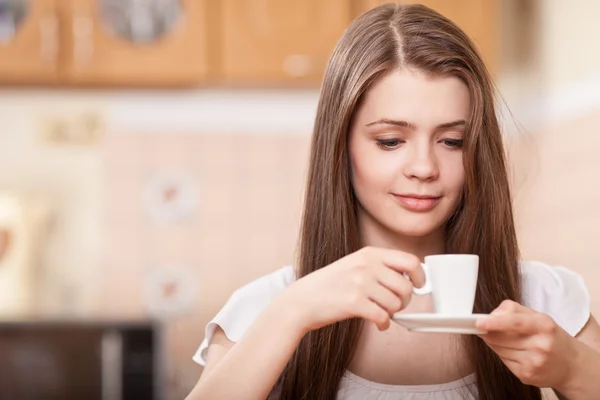 Schöne glückliche junge Frau, die zu Hause Kaffee trinkt — Stockfoto