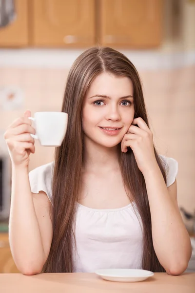 Mooie gelukkig jonge vrouw drinken koffie thuis — Stockfoto