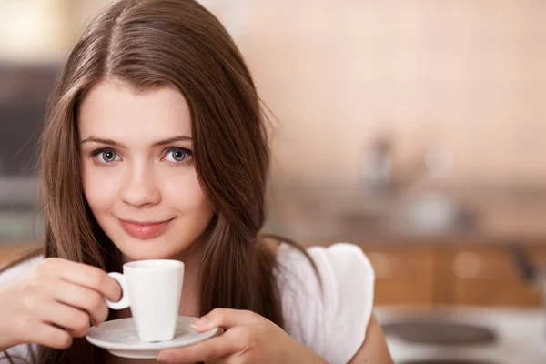 Krásná šťastná mladá žena pití kávy v domácnosti — Stock fotografie