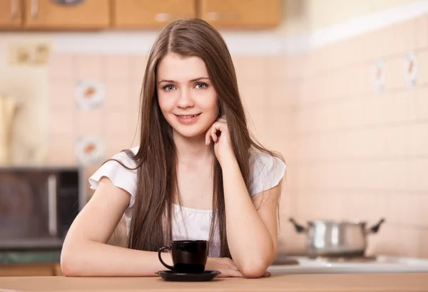 Красивая счастливая молодая женщина пьет кофе дома — стоковое фото