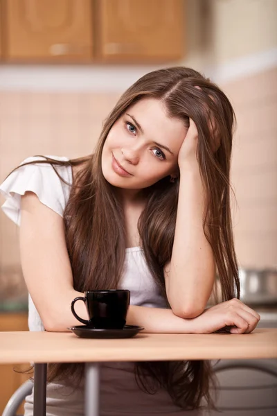 美しい幸せな若い女性は自宅でコーヒーを飲む — ストック写真