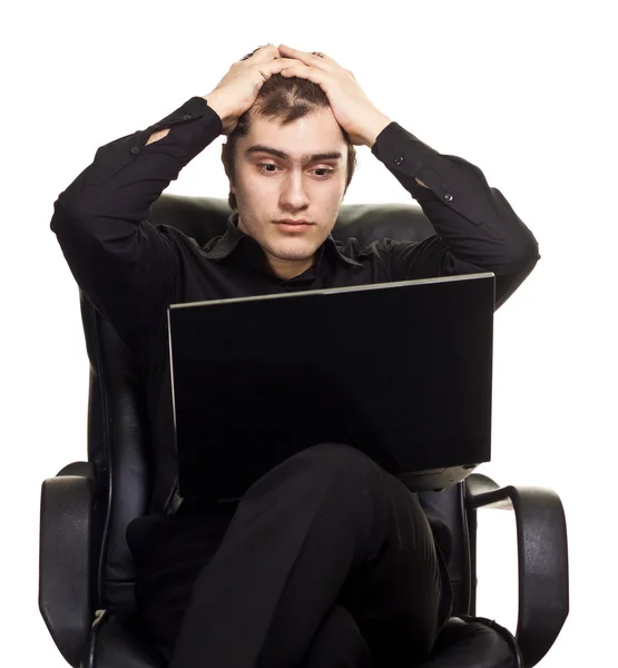 Νεαρός άνδρας, που κάθεται σε μια καρέκλα με φορητό υπολογιστή. απομονώνονται σε λευκό bac — Φωτογραφία Αρχείου