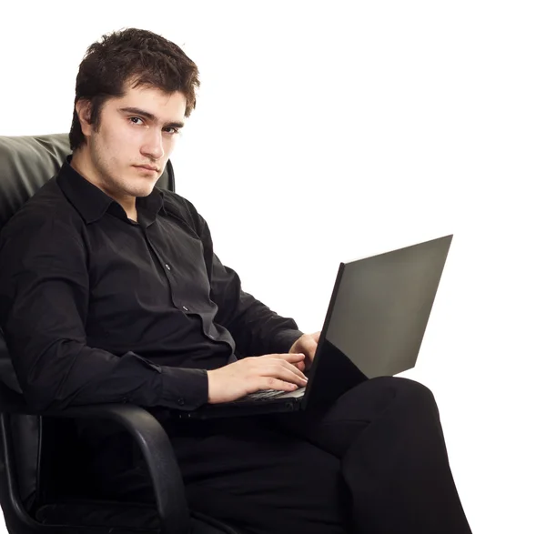 Jovem, sentado em uma cadeira com o laptop. isolado no branco bac — Fotografia de Stock