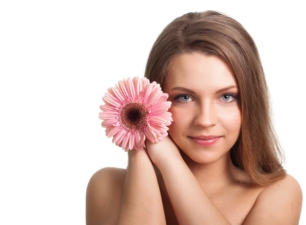 Closeup of a pretty young woman with a pink flower — Stock Photo, Image