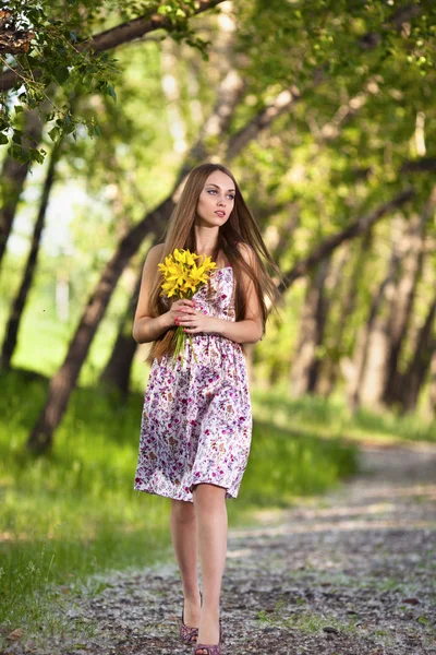 黄色の花が屋外の美しいブロンドの女性の肖像画 — ストック写真