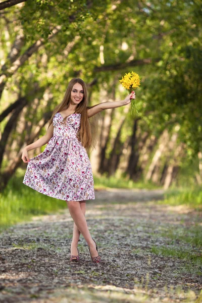 Retrato de una bella mujer rubia con flores amarillas al aire libre —  Fotos de Stock