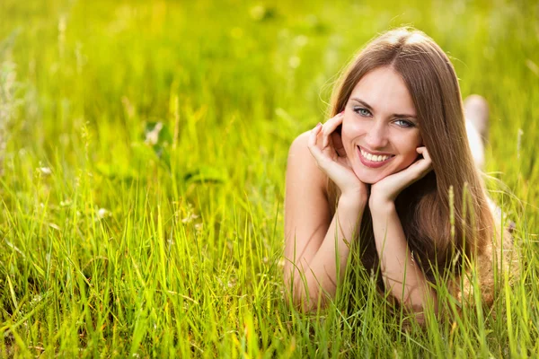 Sıcak yaz gününde çayır üzerinde güzel sarışın genç kadın — Stok fotoğraf
