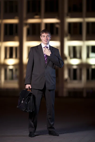 Empresario guapo con maletín en la ciudad de noche en el centrico — Foto de Stock