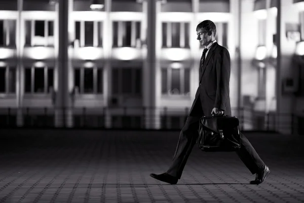 Empresario guapo con maletín en la ciudad de noche en el centrico —  Fotos de Stock