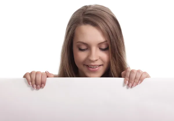 Jonge vrouw op zoek naar beneden een witte bord — Stockfoto