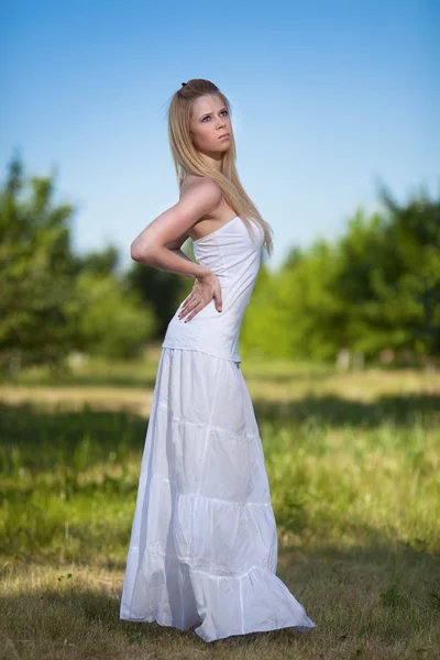 Vackra unga blonda kvinnan i park — Stockfoto
