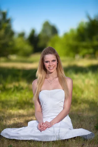 Mooie jonge blonde vrouw in park — Stockfoto