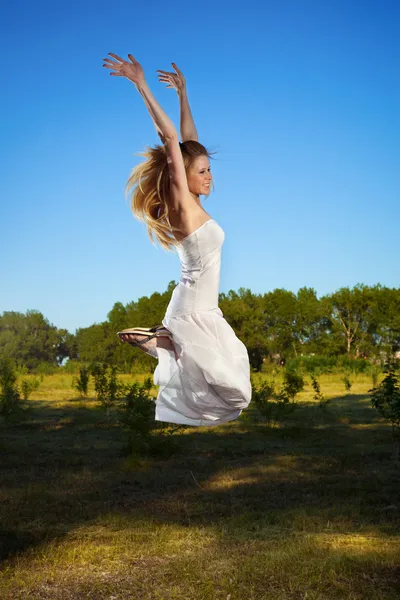 Heureuse jeune femme sauter en plein air — Photo